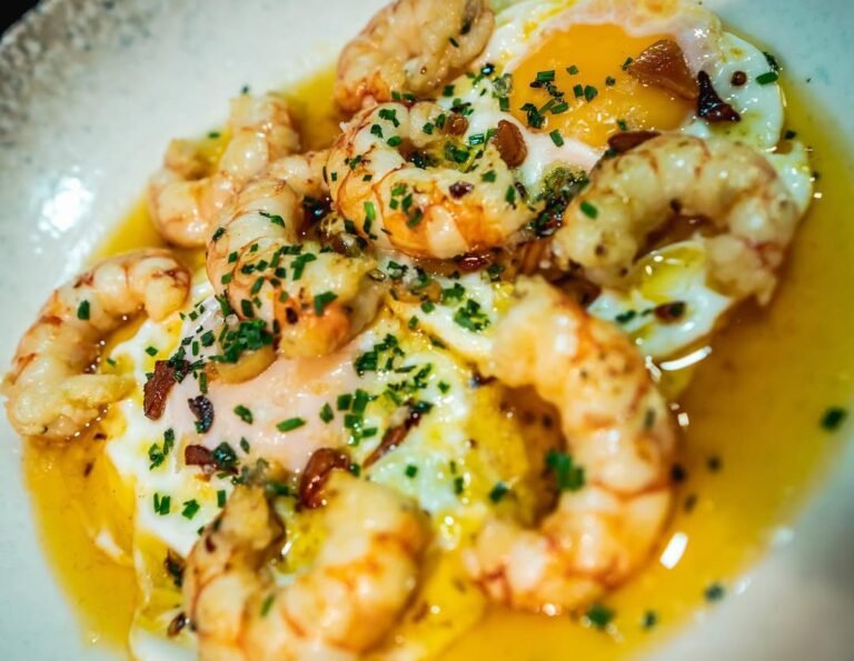 Huevos rotos con gambón al ajillo